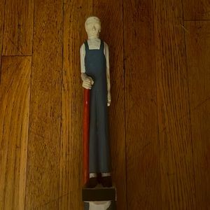 Carved wooden sculpture of elderly man standing on a snake.